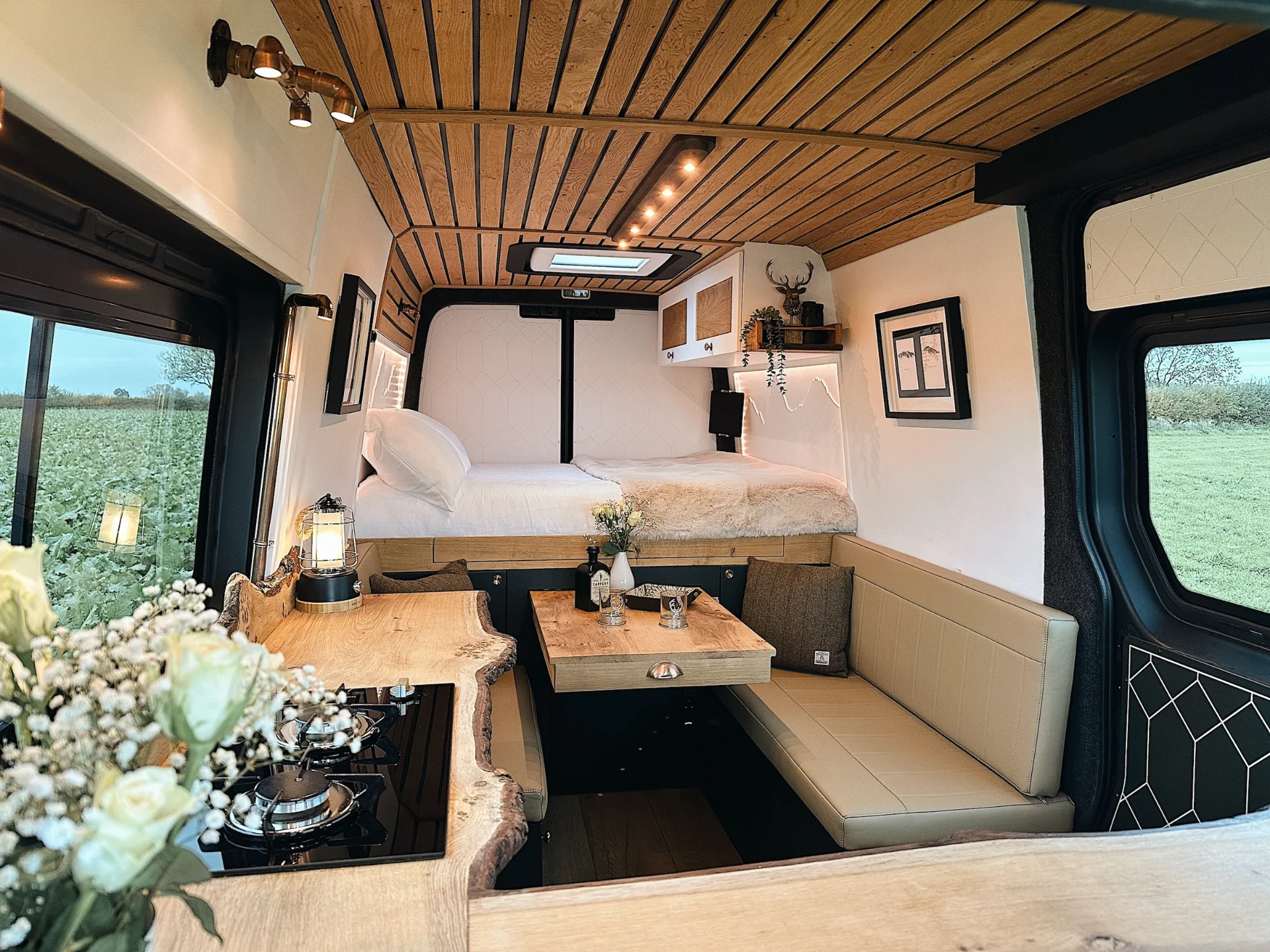 Handcrafted campervan interior with timber ceiling, kitchen and double bed